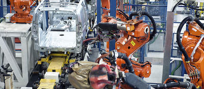 Vehicle factory manufacturing with robotic arms and automation.