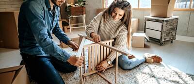 Young couple assembling furniture for new home