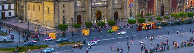 Image of a government building and foot traffic on a busy street in Mexico City, Mexico.