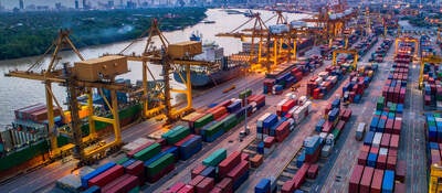 Container cargo ship and cargo plane with working crane bridge in shipyard at sunrise