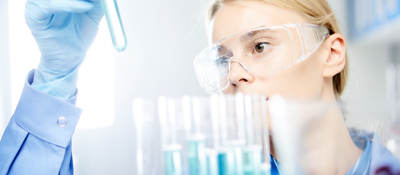 Young woman working in laboratory, handling test tubes