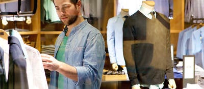 A man browses different articles of clothing.