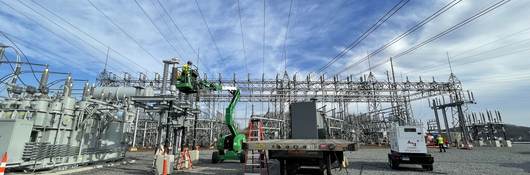 Worker inspecting high voltage cables.