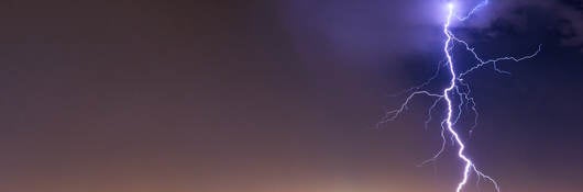 lightning striking cityscape at night 