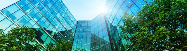 Low angle view of multi-story glass front modern office building