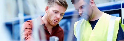 two young men conducting cable inspection for compliance