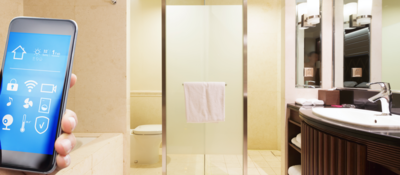 A hand holds a smartphone while in a modern bathroom